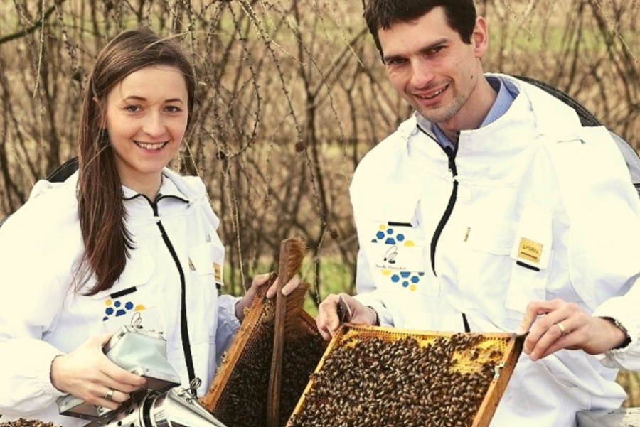 lidia-morawska-i-mateusz-morawski-przy-ulach-prezentuja-narzedzia-pszczelarskie-pasieka-morawskich-ekologiczne-miody-z-certyfikatem