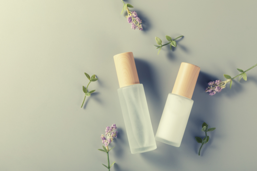 szklane-butelki-z-hydrolatami-kwiaty-na-jasnoszarym-tle