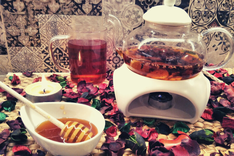 zaparzony-napar-z-imbirem-w-szklanym-dzbanku-w-tle-rozsypane-suszone-kwiaty