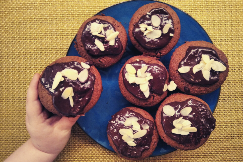 zdrowo-tutaj-przepis-na-zdrowe-muffinki-pelnoziarniste-skladniki-potrzebne-do-wykonania-maslo-jajka-maka-cynamon-kakao-czekolada-rozlozone-na-niebieskich-talerzykach-drewniane-tlo