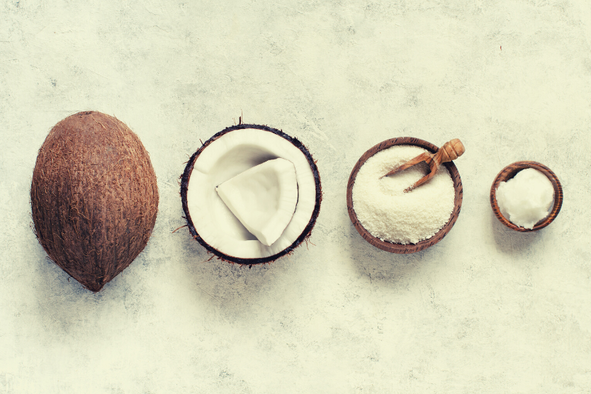 olej-kokosowy-na-skore-caly-kokos-pol-kokosa-drewniana-miseczka-z-wiorkami-kokosowymi-olej-kokosowy-w-malej-drewnianej-misce-ulozone-od-najwiekszego-do-najmniejszego-widok-z-gory
