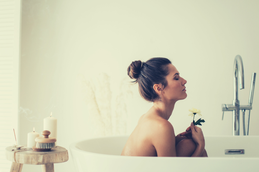 kapiel-w-platkach-owsianych-8-przepisow-relaksujaca-kapiel-moda-kobieta-w-wannie-z-kwiatkiem-w-dloni