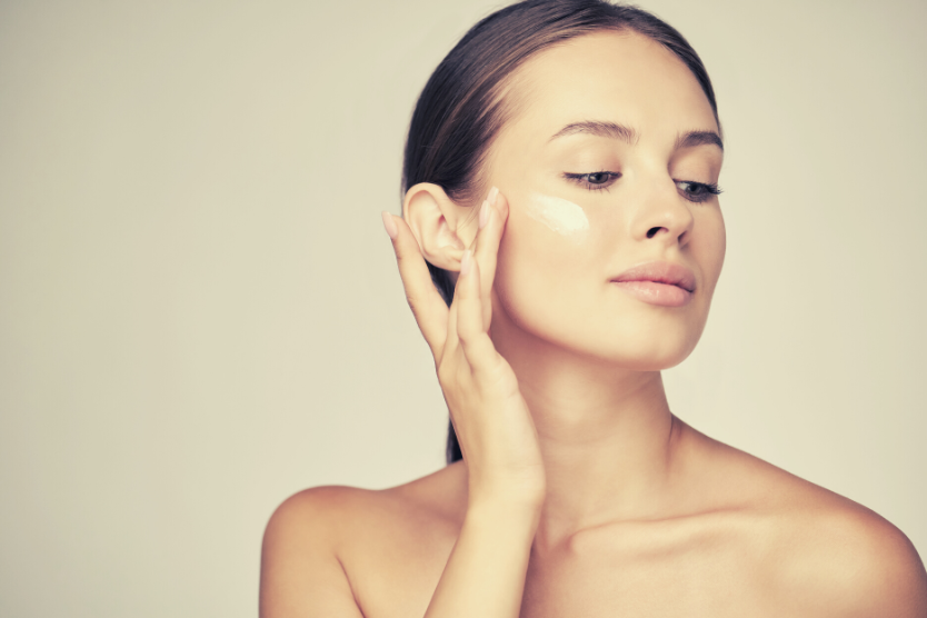 portret-mlodej-pieknej-kobiety-z-kremem-na-twarzy-odsloniete-ramiona-idealna-cera-na-jasnym-tle